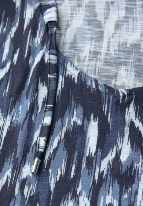 Nahaufnahme eines blauen Stoffes mit abstraktem Muster und Kordelzug.